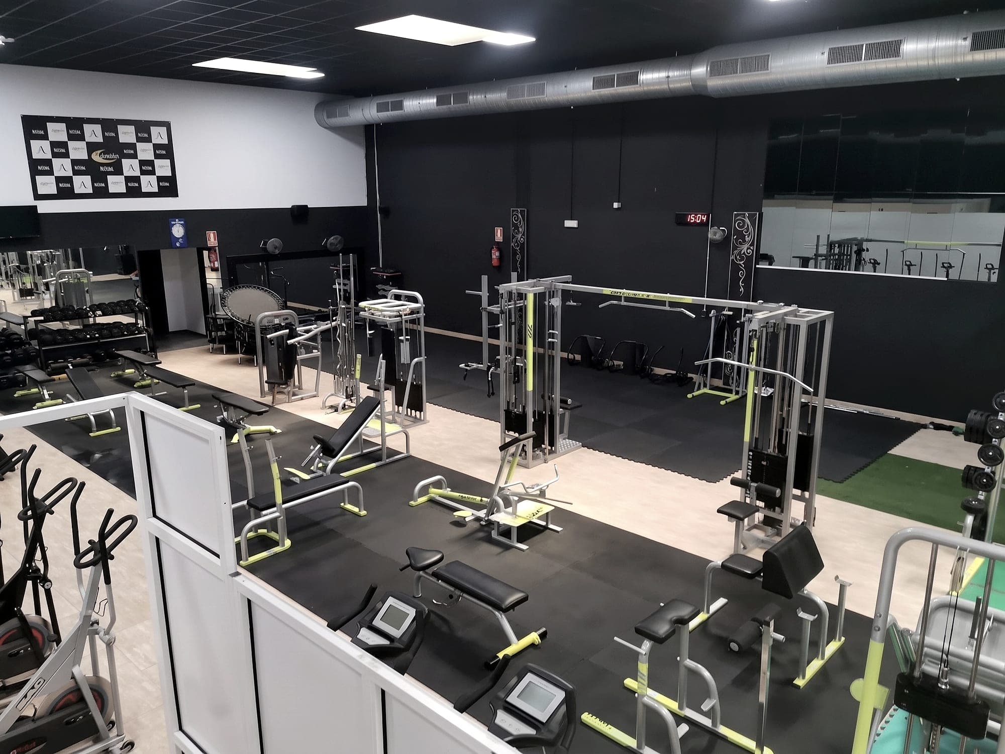 Sala principal de Wellness Aracena: máquinas de poleas, bancos y zona de peso libre